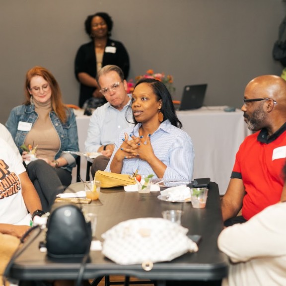 A women speaks with other people listening closely to her words