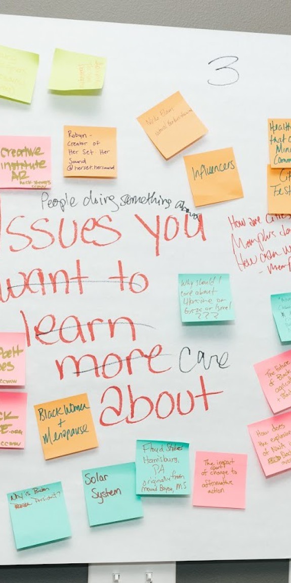 Sticky notes with story ideas cover a board
